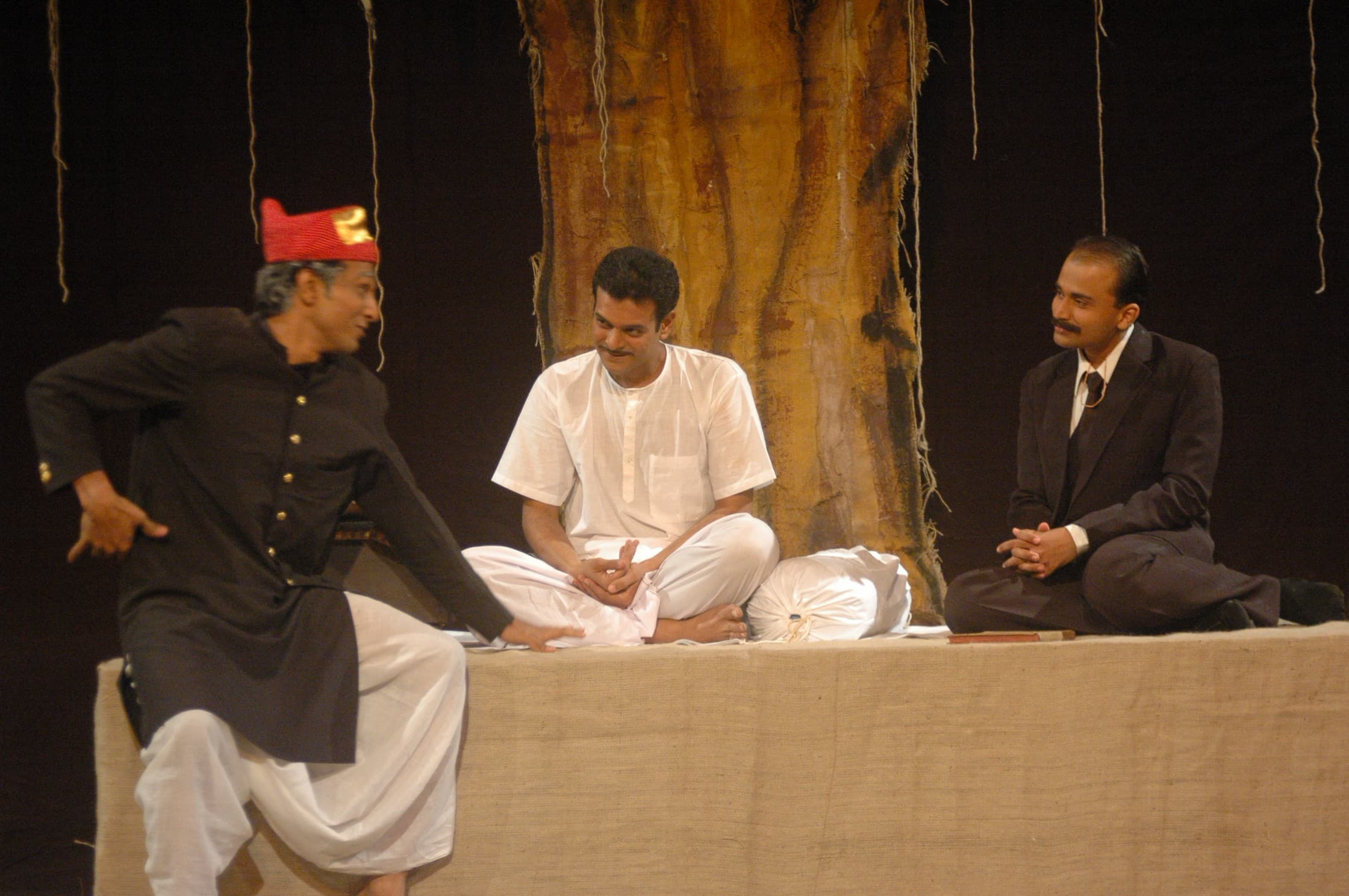 The three actors of Apurva Avsar — Rajchandra in white, flanked by centuries of seekers